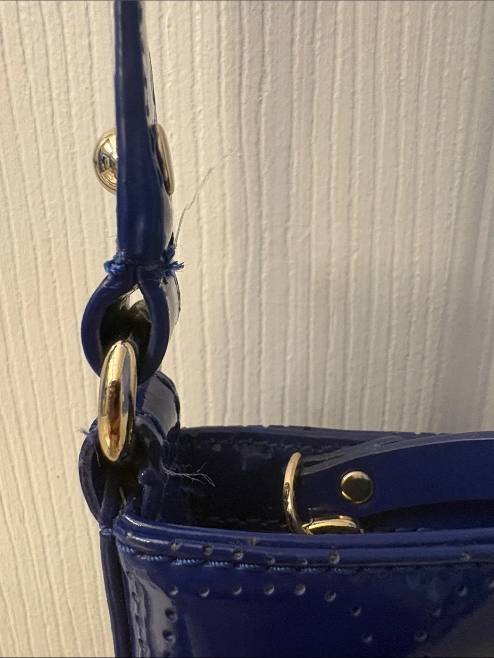 Kate Spade heart perforated patent leather crossbody in cobalt blue.